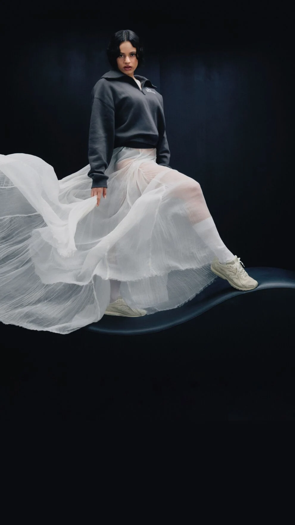 Rosal&iacute;a standing in front of a black studio backdrop. 